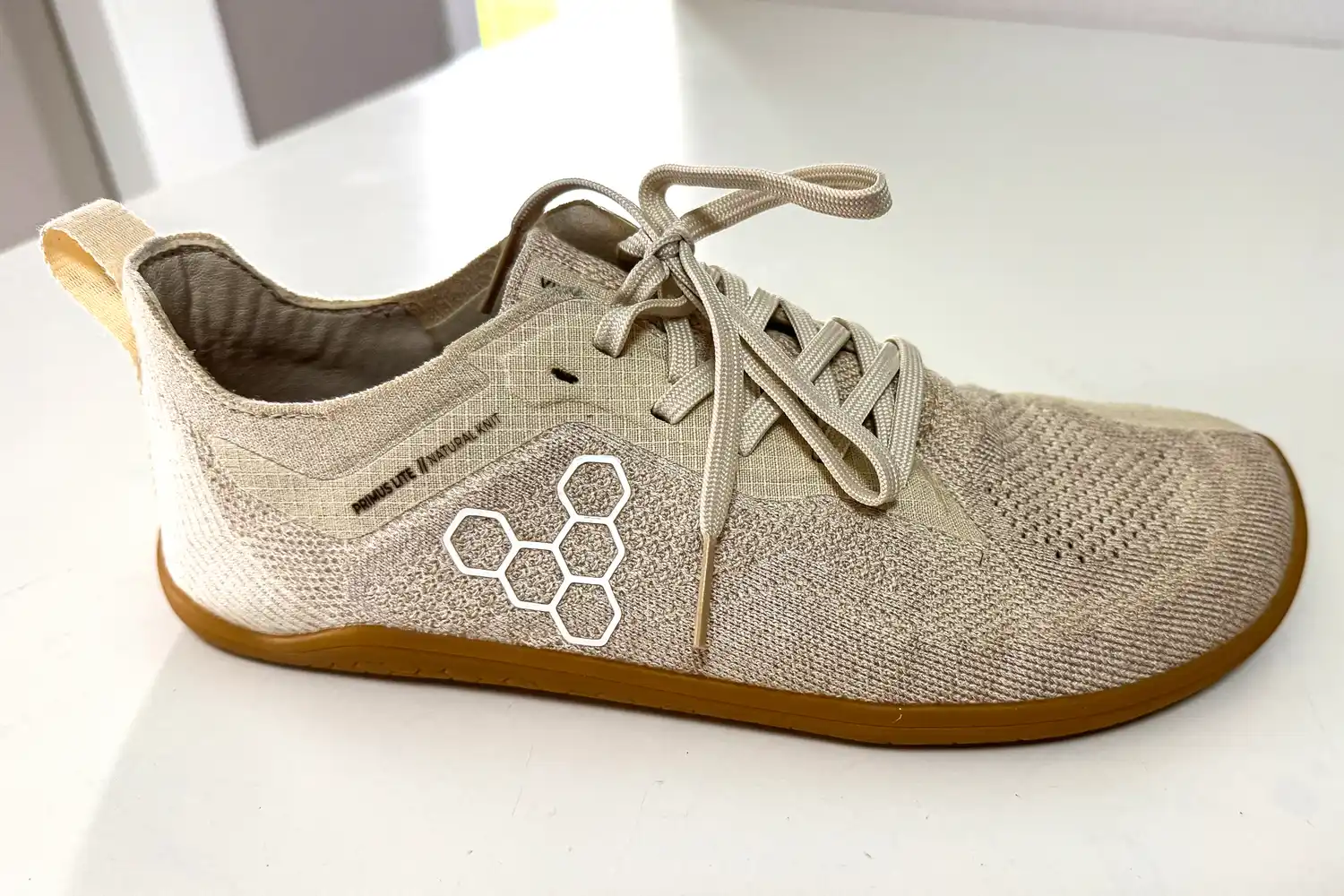 A side view of the Vivobarefoot Women's Primus Lite Knit Natural Sneaker