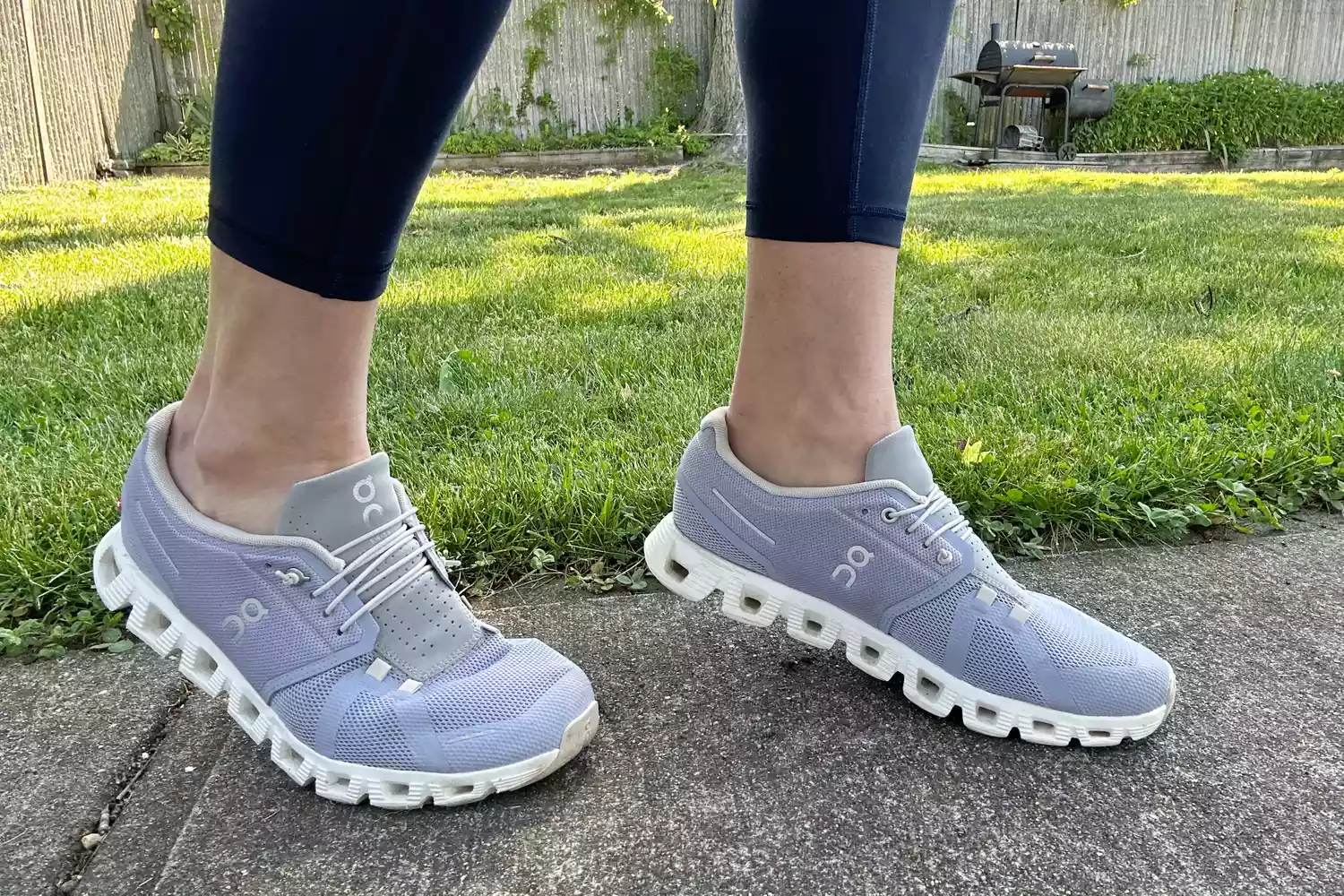 Person wearing ON Cloud 5 Sneakers on sidewalk