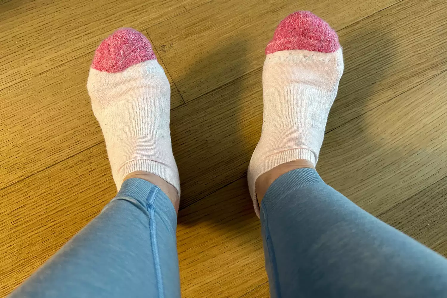 Feet wearing Bombas Women's Marl Ankle Socks on wood floor