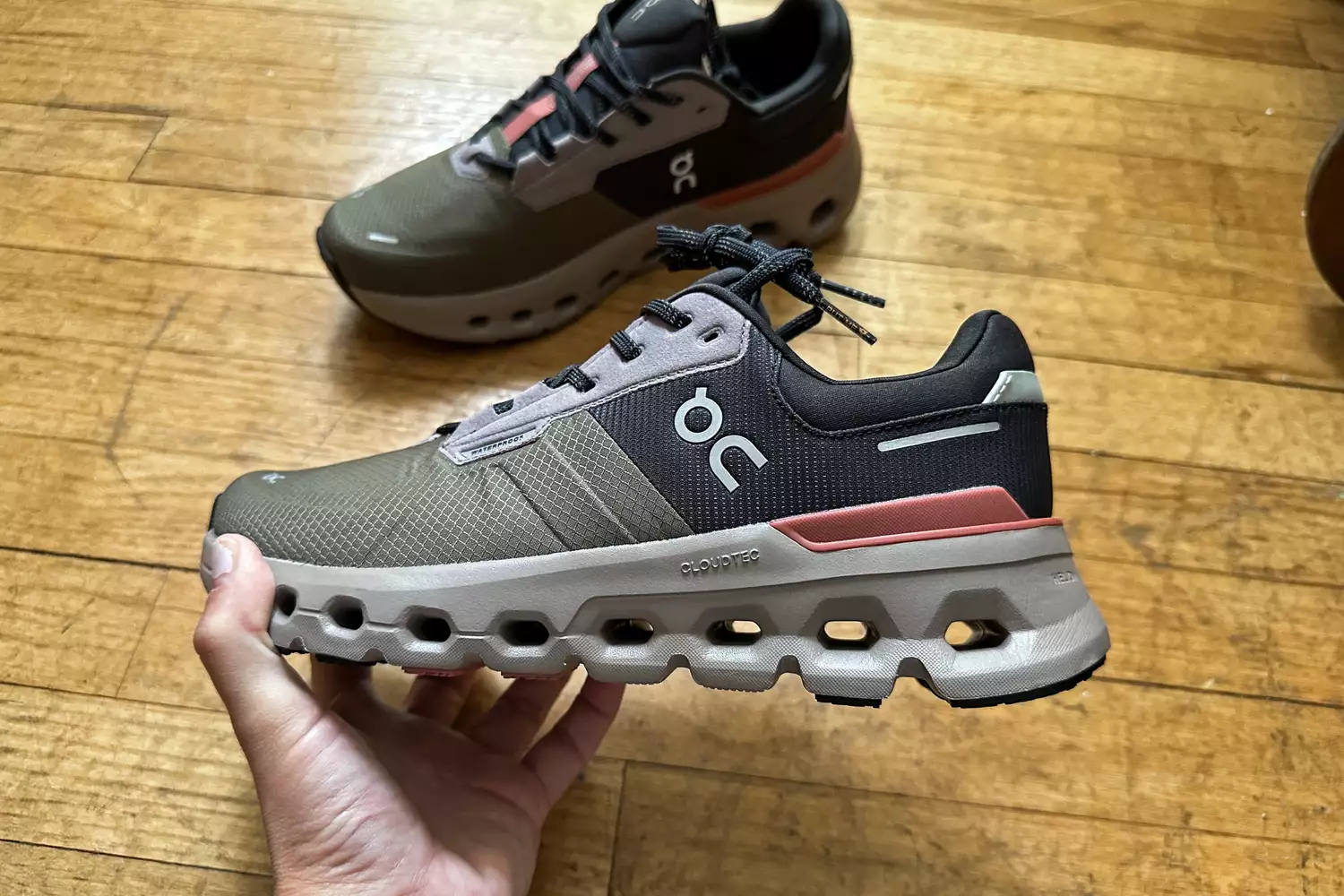 A person holds up the On Women's Cloudrunner 2 Running Shoe