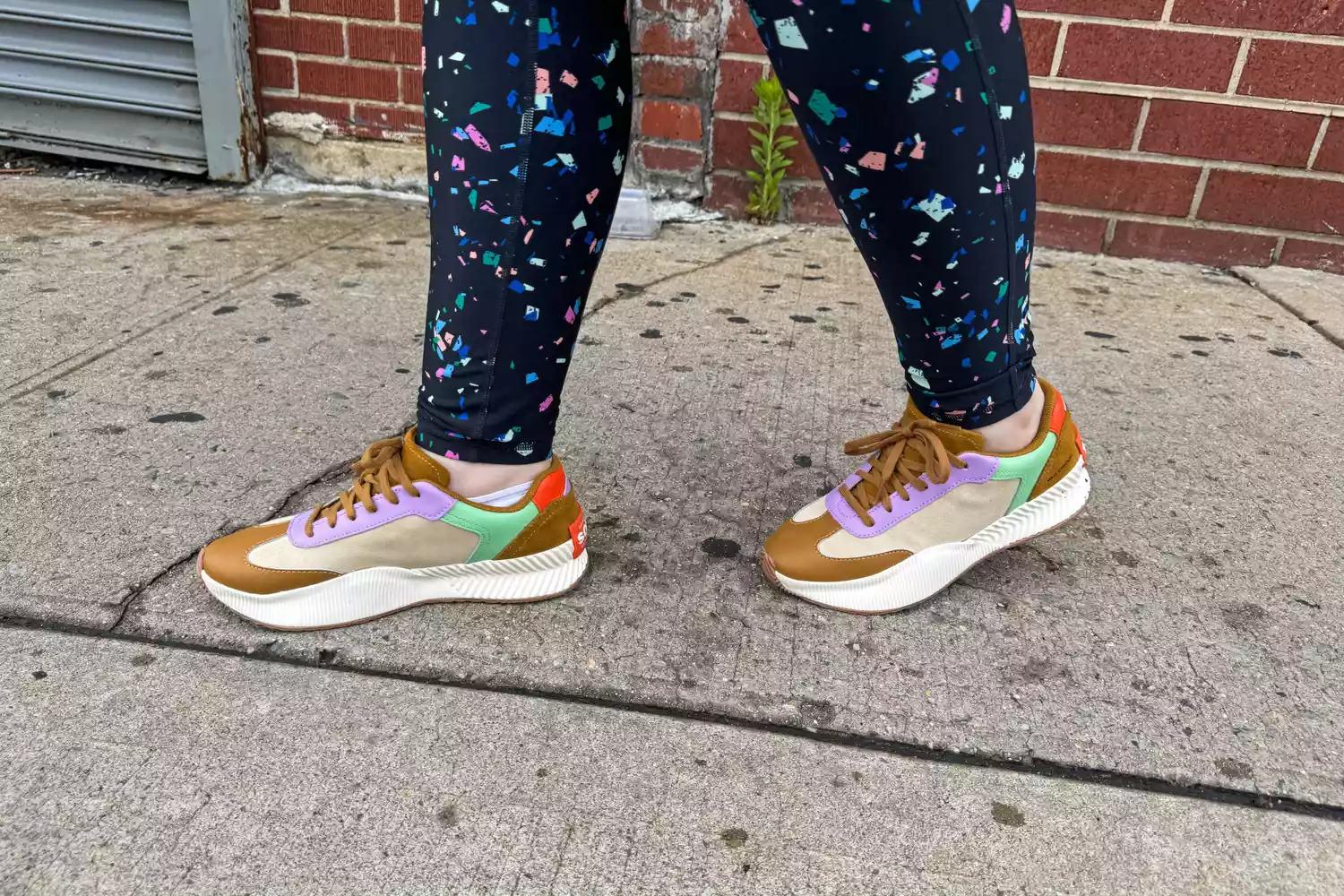 A person walks outside on concrete while wearing the Sorel ONA Blvd Classic Womenâs Waterproof Sneakers