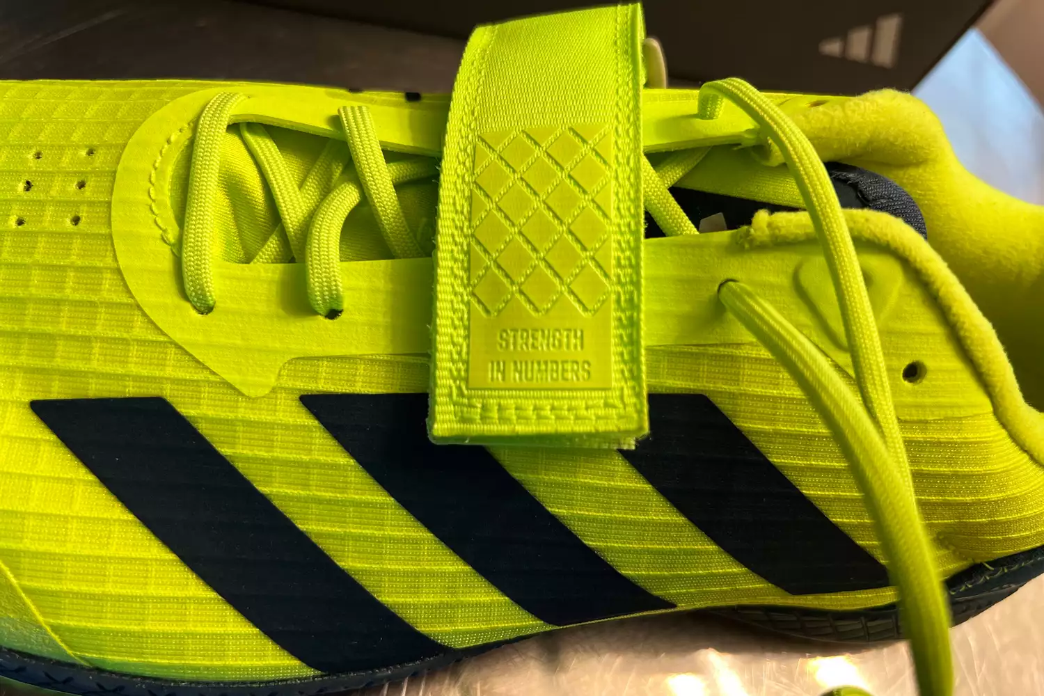 The Velcro strap on the top of the adidas The Total Shoes Unisex Weightlifting Sneakers