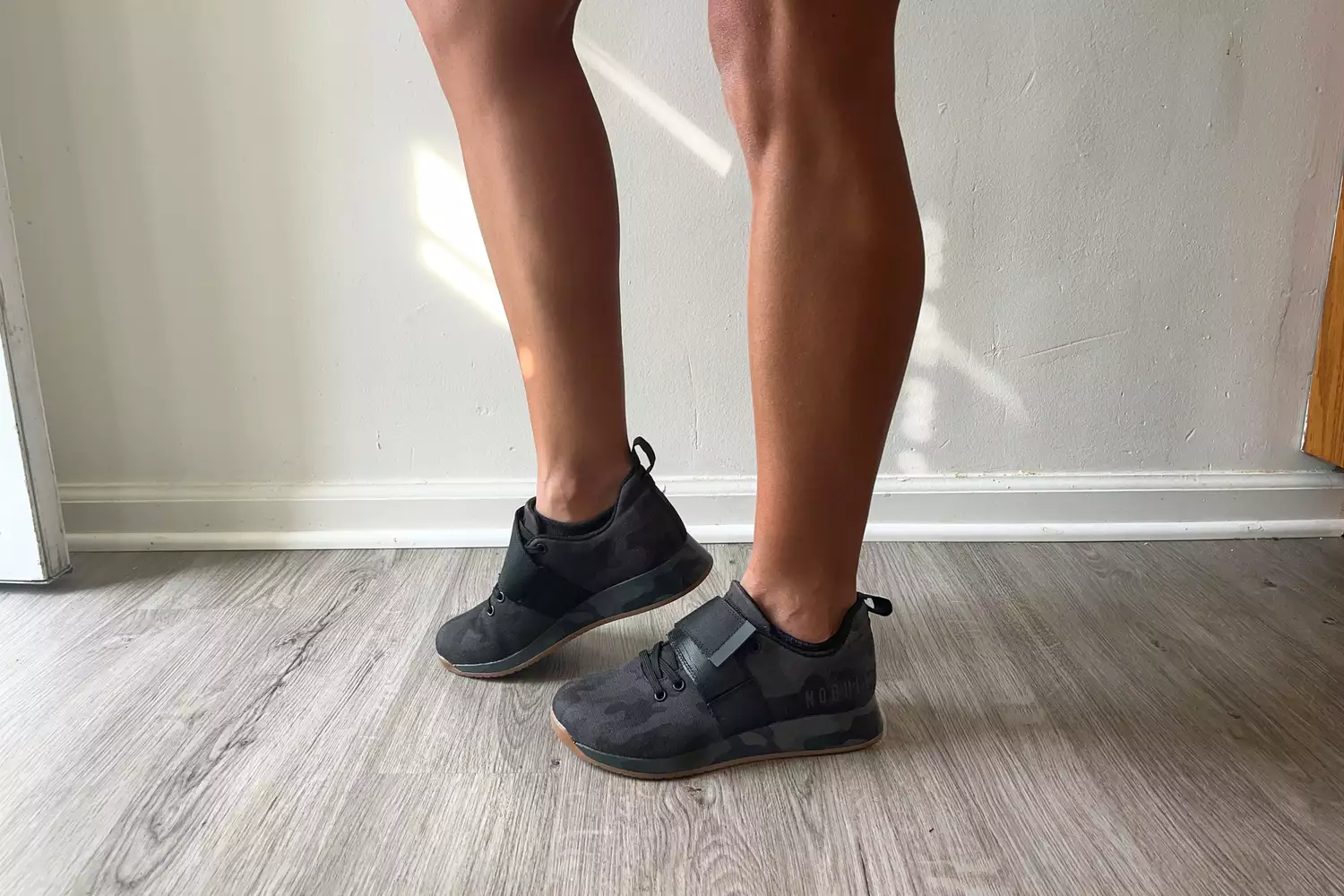 A person stands while wearing the NOBULL Women's Canvas Lifter Shoe