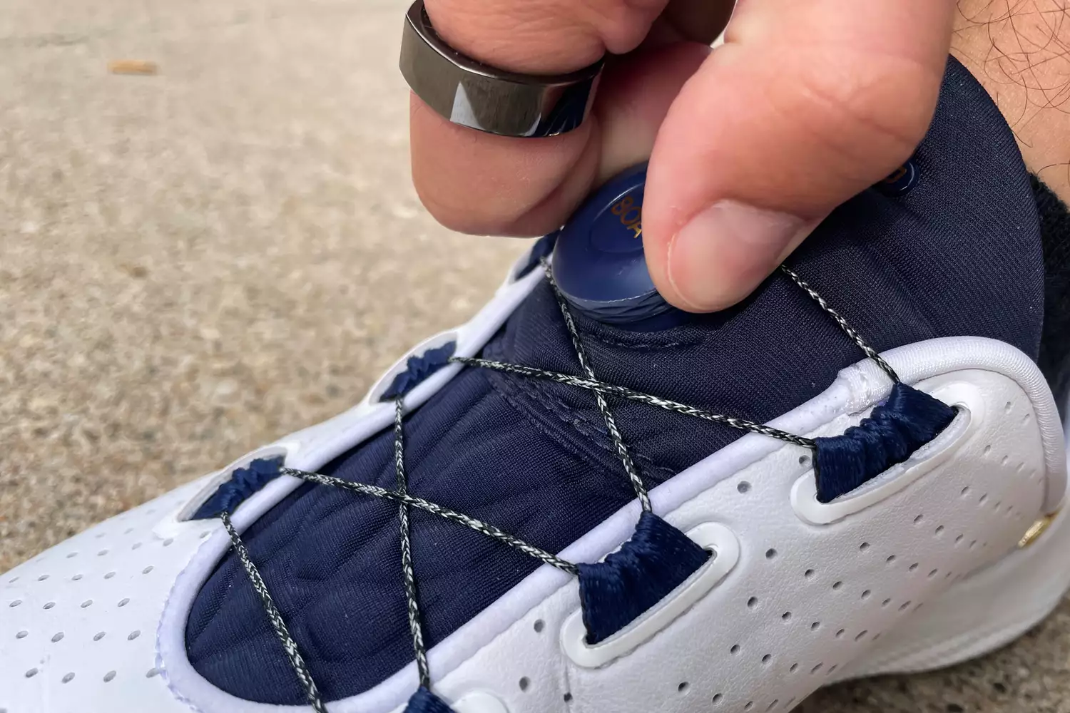 A person adjusts the Under Armour Unisex UA SlipSpeed Training Shoe