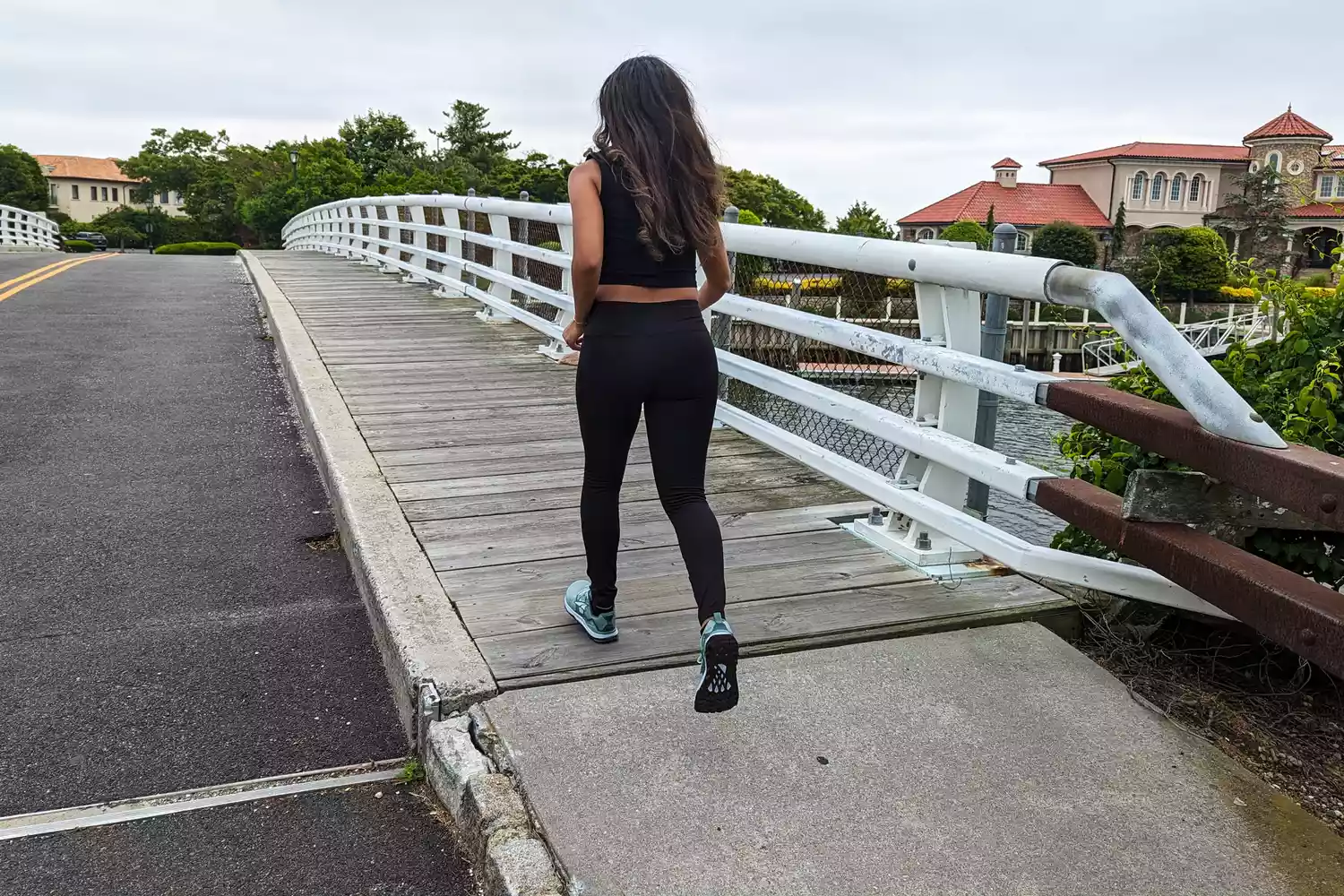 A person walking on a bridge in the Altra Lone Peak 8 Trail Running Shoes