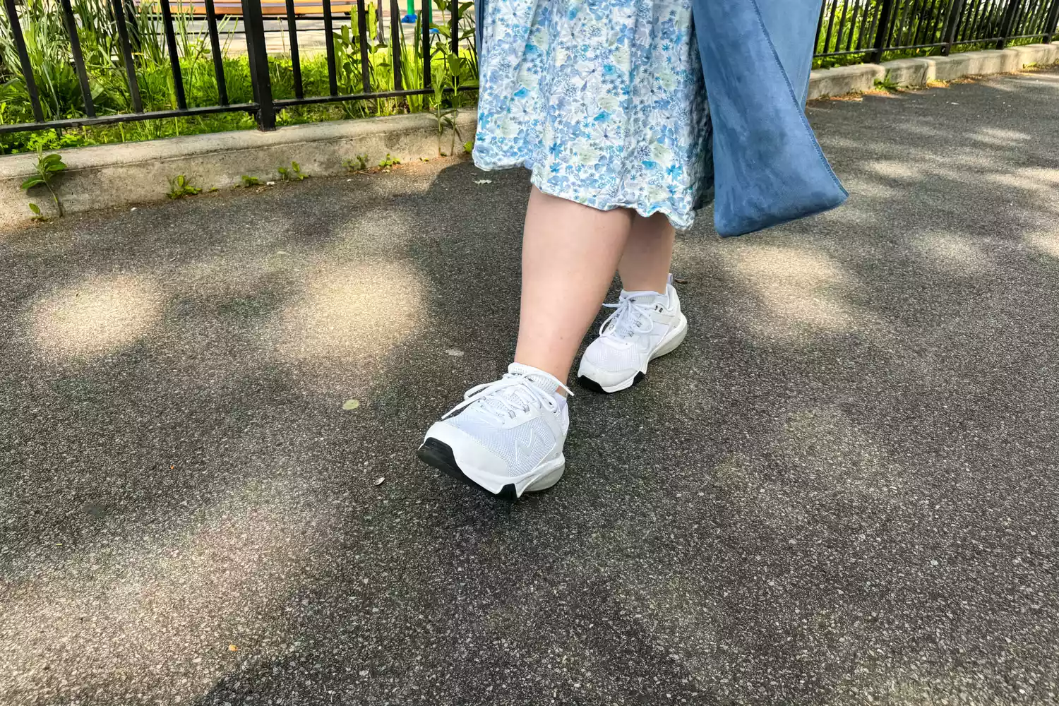 A person walking on blacktop in the MBT Women&acirc;s Sport 4 II shoes