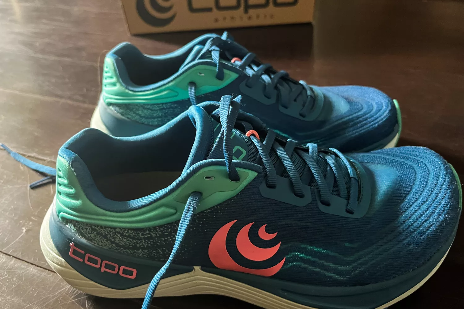 The Topo Athletic Women&acirc;s Ultrafly 5 shoes on a wooden floor