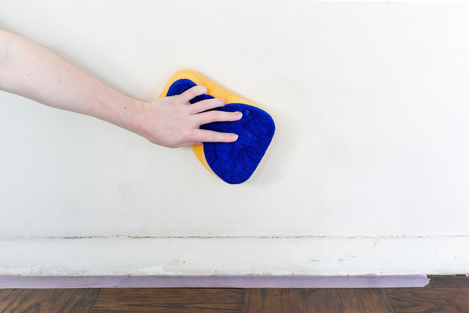 wiping walls down with a sponge