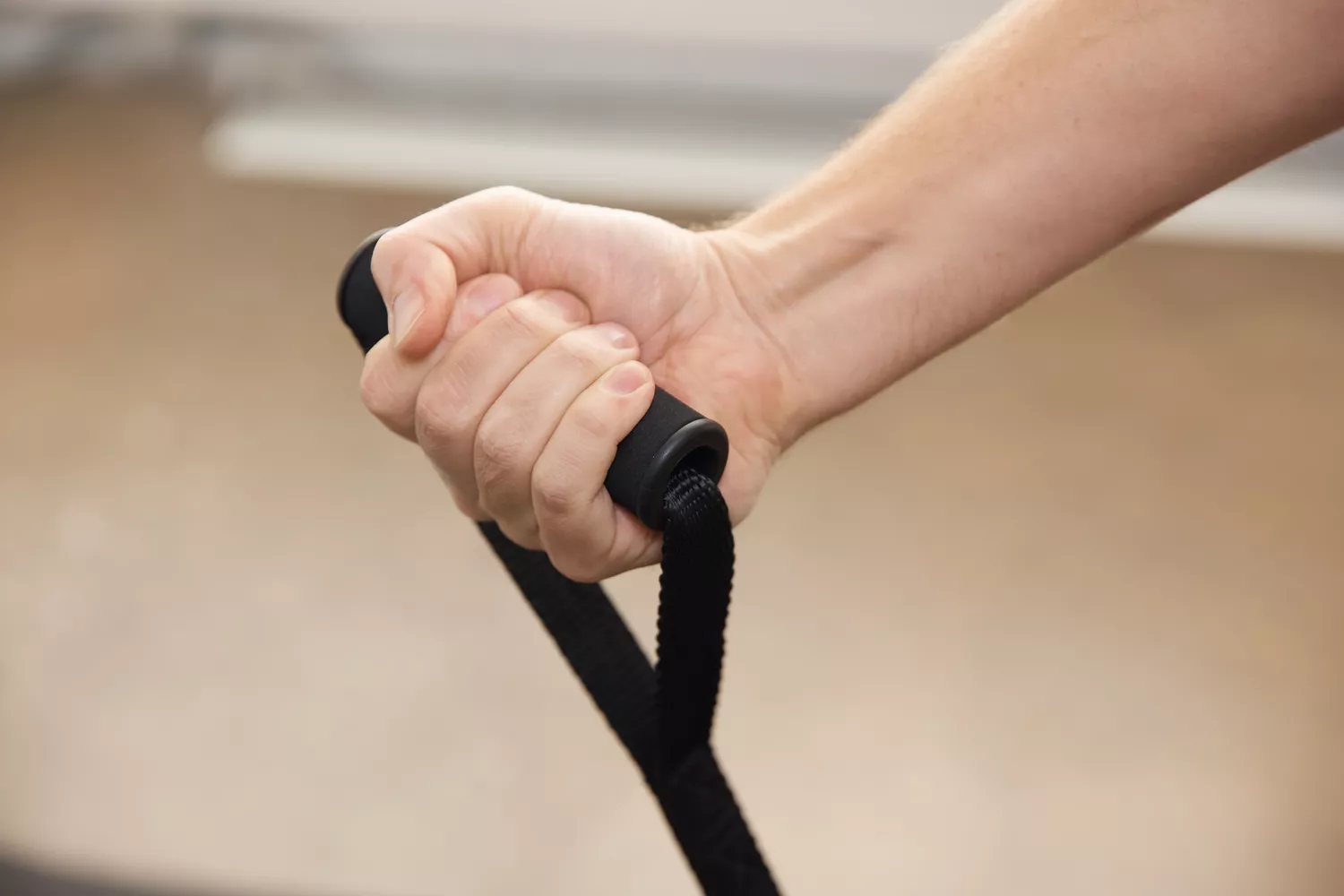 Hand holding handle of the Whatafit Resistance Bands Set