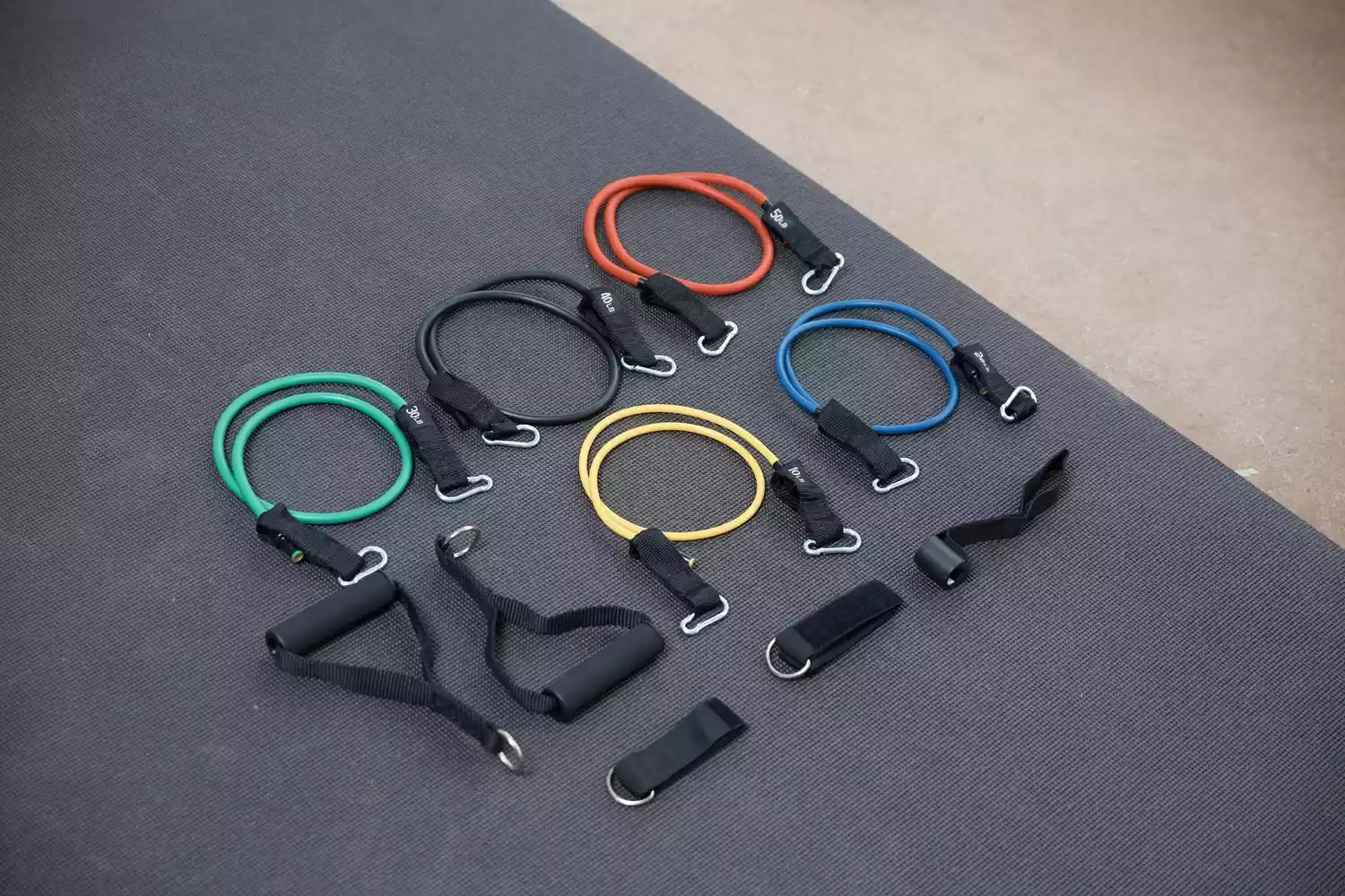 Whatafit Resistance Bands Set displayed on a black gym mat