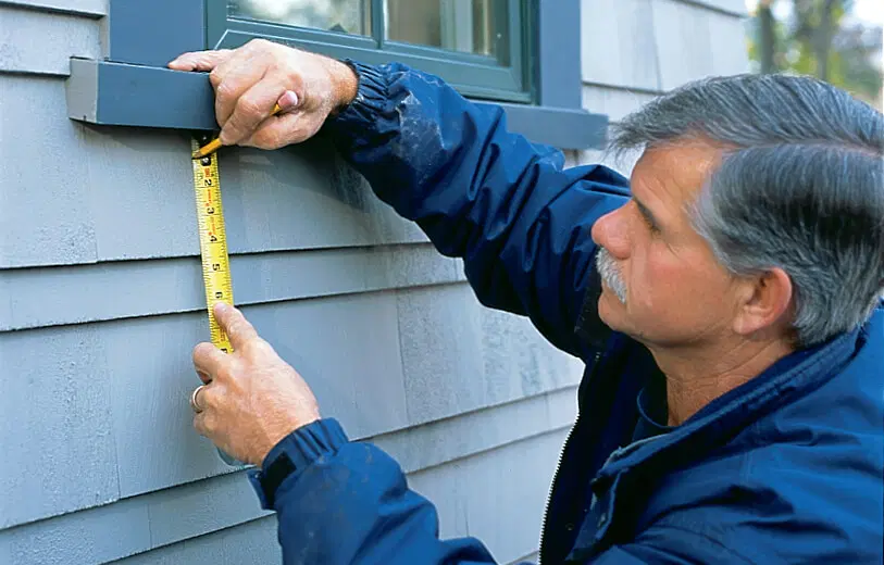 Tom Silva measures and marks where a window box will be installed.