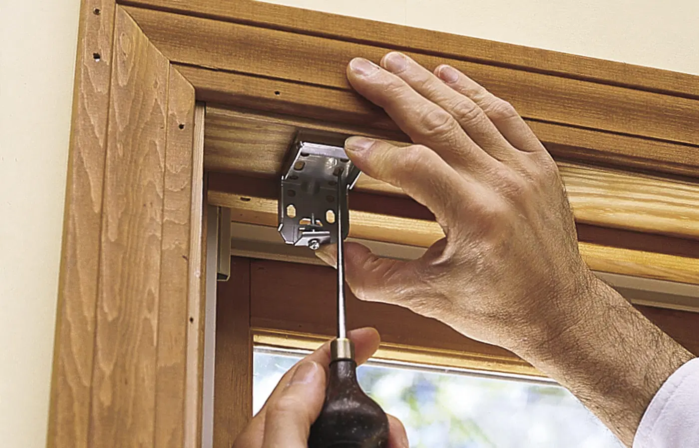 Screw hole locations for a window shade being marked.