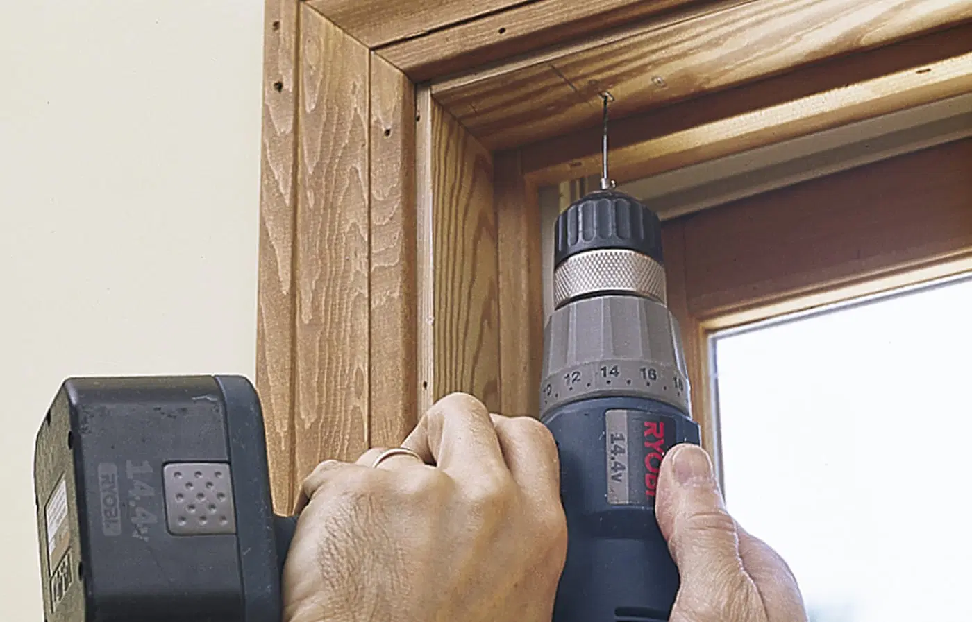A drill being used to make pilot holes for window shades.