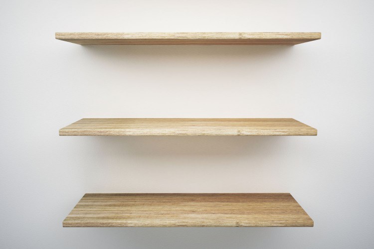 Wooden shelves mounted on white wall