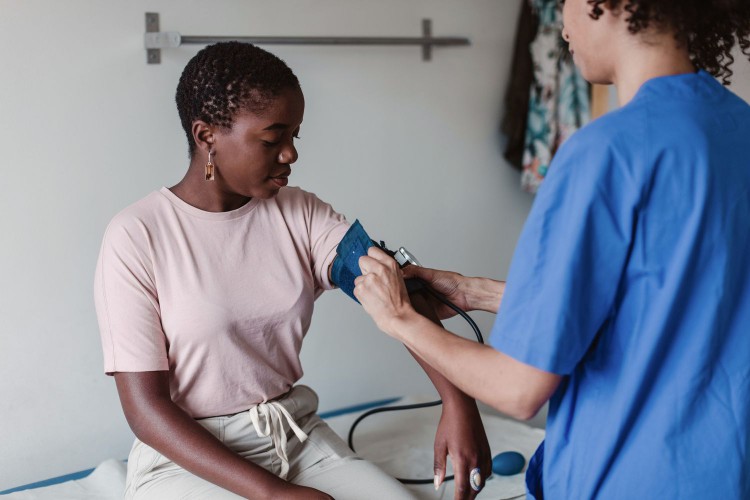 woman having blood pressure taken at doctor's office