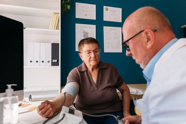 healthcare provider measuring blood pressure of older woman