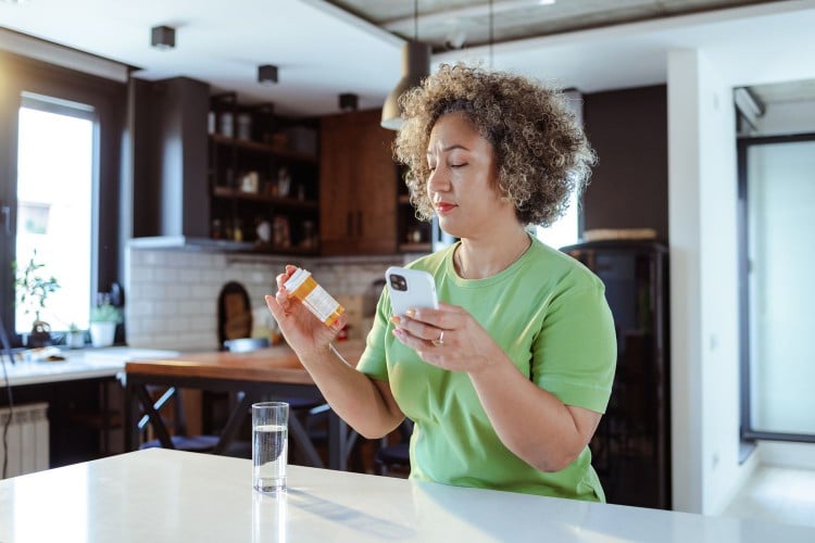 Woman reading back of medication label