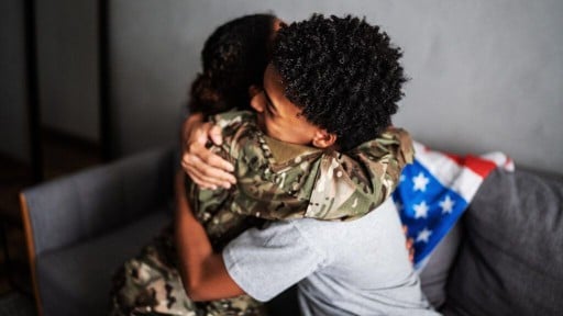 A female Army veteran hugs another woman