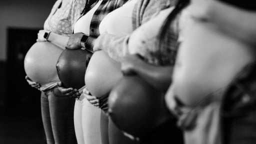 Five pregnant women hold their bellies