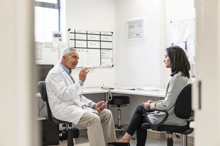 Male doctor talking to female patient